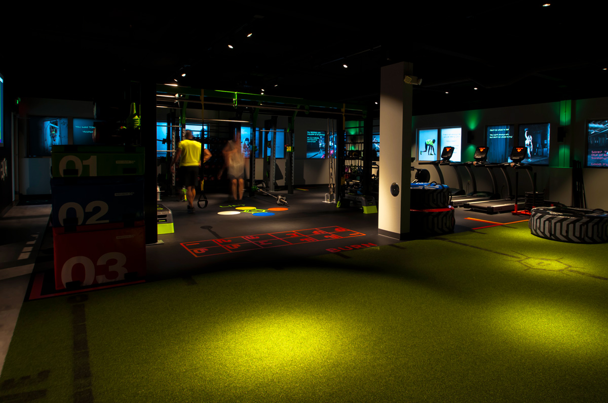 Carbon World Health Training Studio Wide View Wide view of training studio at Carbon World Health with turf floor, numbered training zones, video wall displays, and cardio equipment
