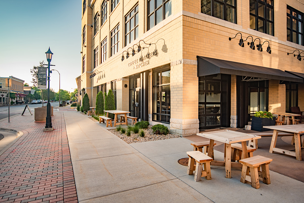 Exterior of Coffee Roasters and Kitchen at Middleton Center with outdoor bench seating and brick facade