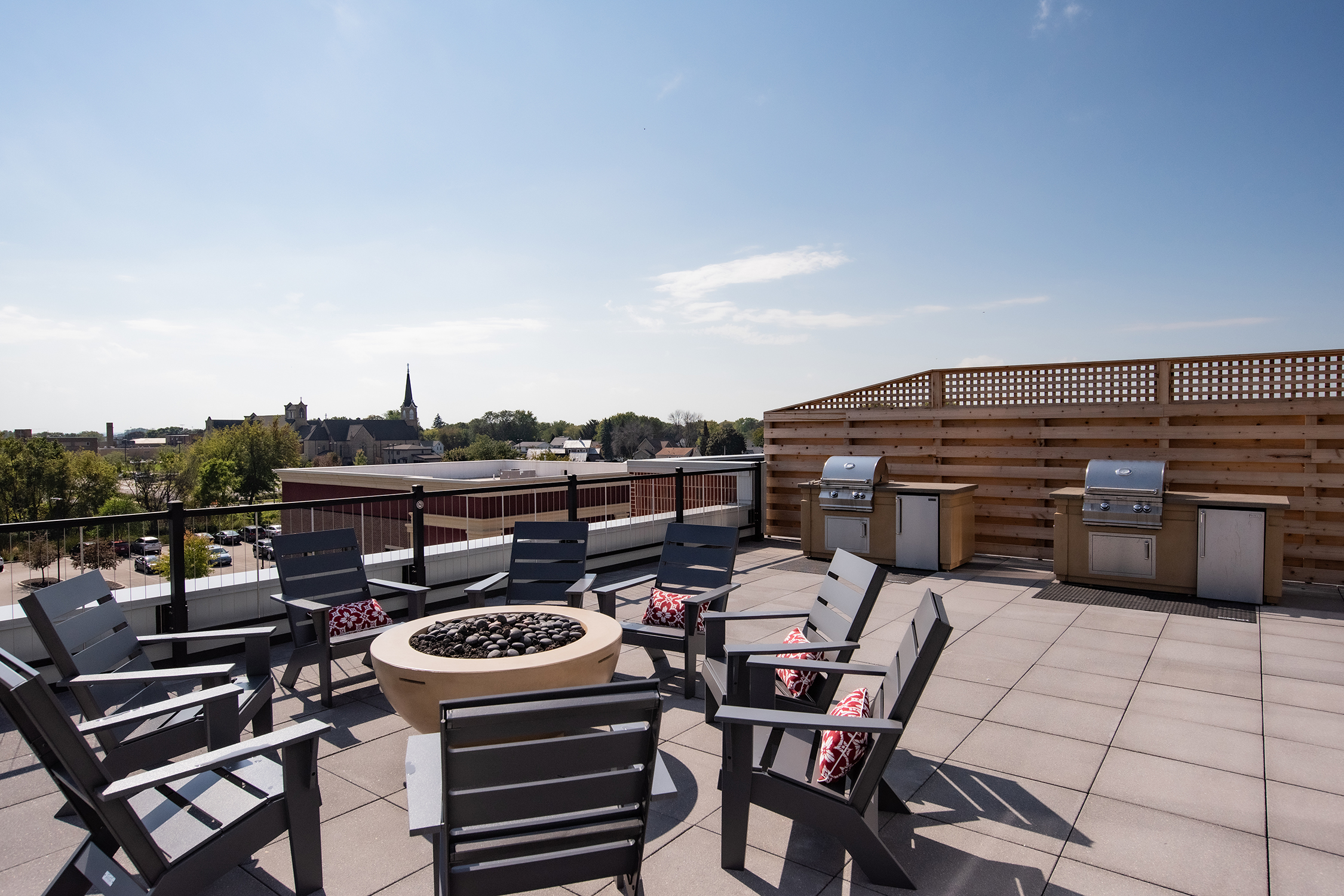 Rooftop patio at Lamphouse with fire pit, lounge seating, outdoor grills, and views of the surrounding city