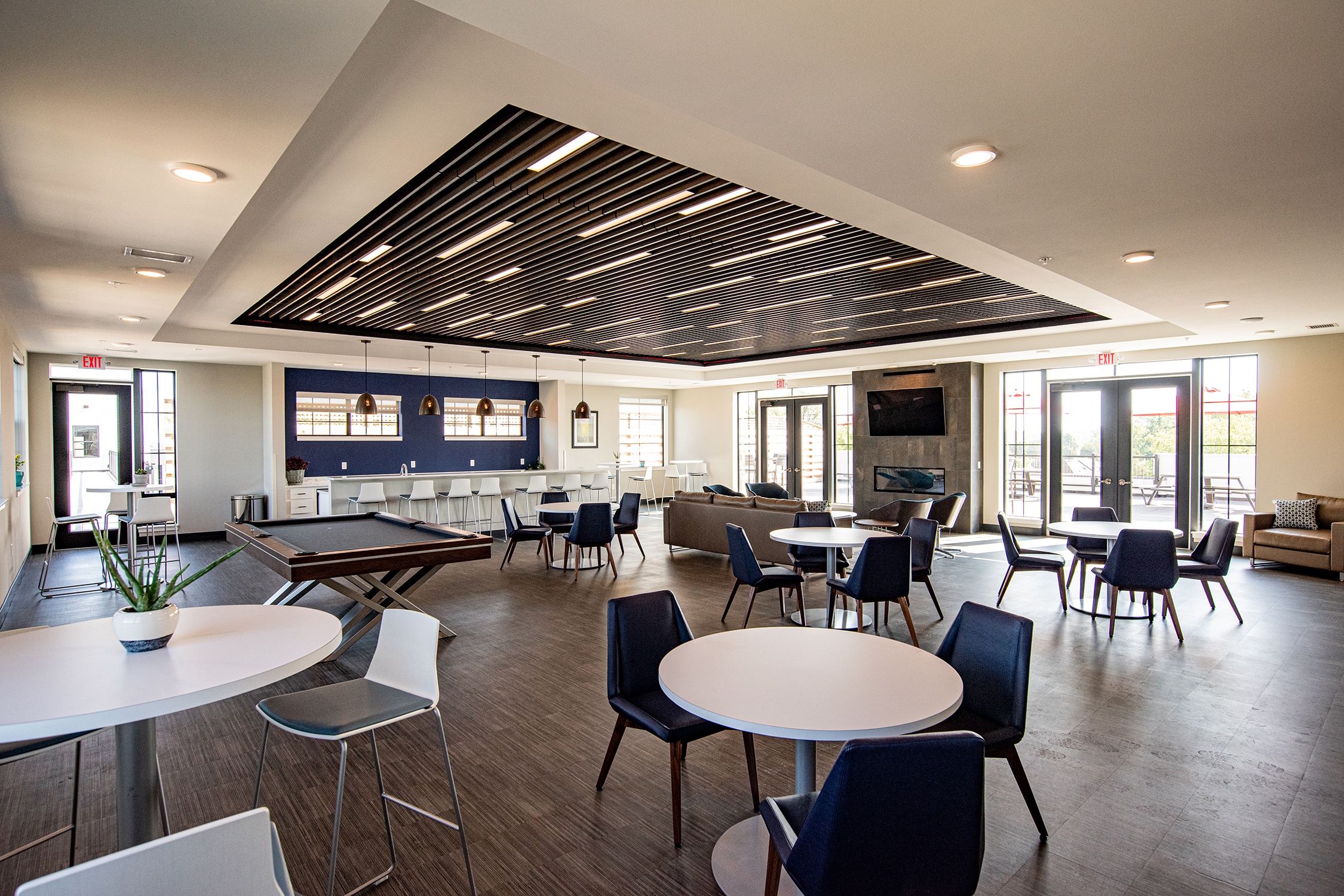 Lamphouse Clubroom Interior Community clubroom at Lamphouse with billiards table, lounge seating, slatted wood ceiling detail, and access to outdoor patio