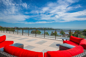Rooftop patio at Peloton Residences with red lounge furniture and panoramic lake and city views