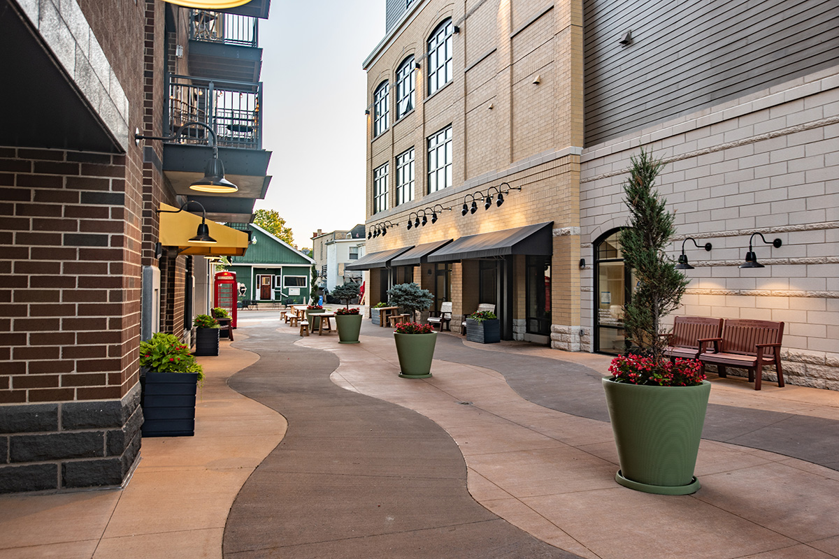 Middleton Center Pedestrian Courtyard Pedestrian courtyard at Middleton Center with retail storefronts, outdoor seating, planters, and red phone booth accent