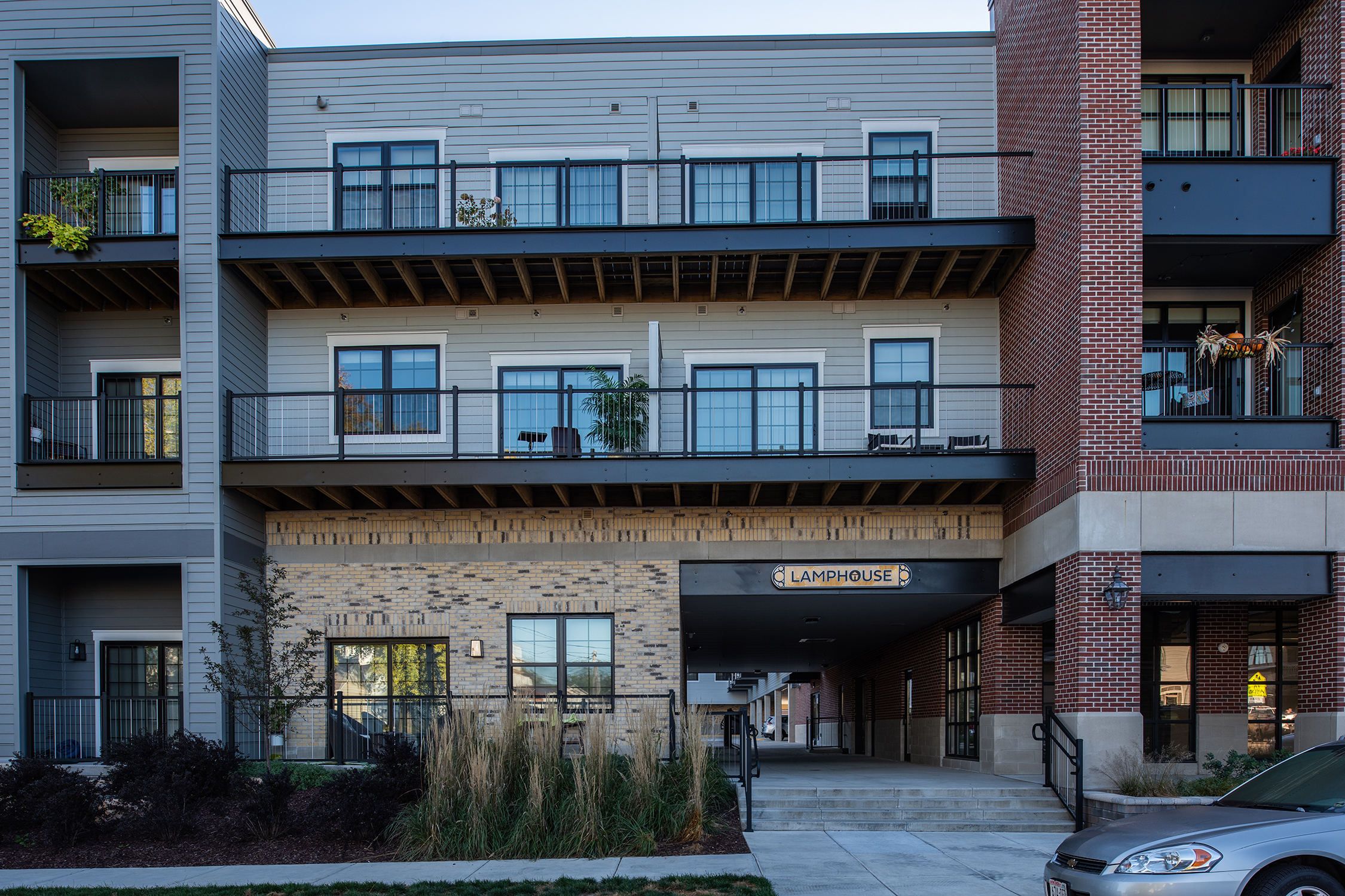 Close-up of Lamphouse building entry with brick facade, upper-floor balconies, and Lamphouse retail signage at street level