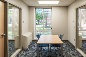Small study room at Beloit College Whitney Hall with table, chairs, and windows overlooking campus