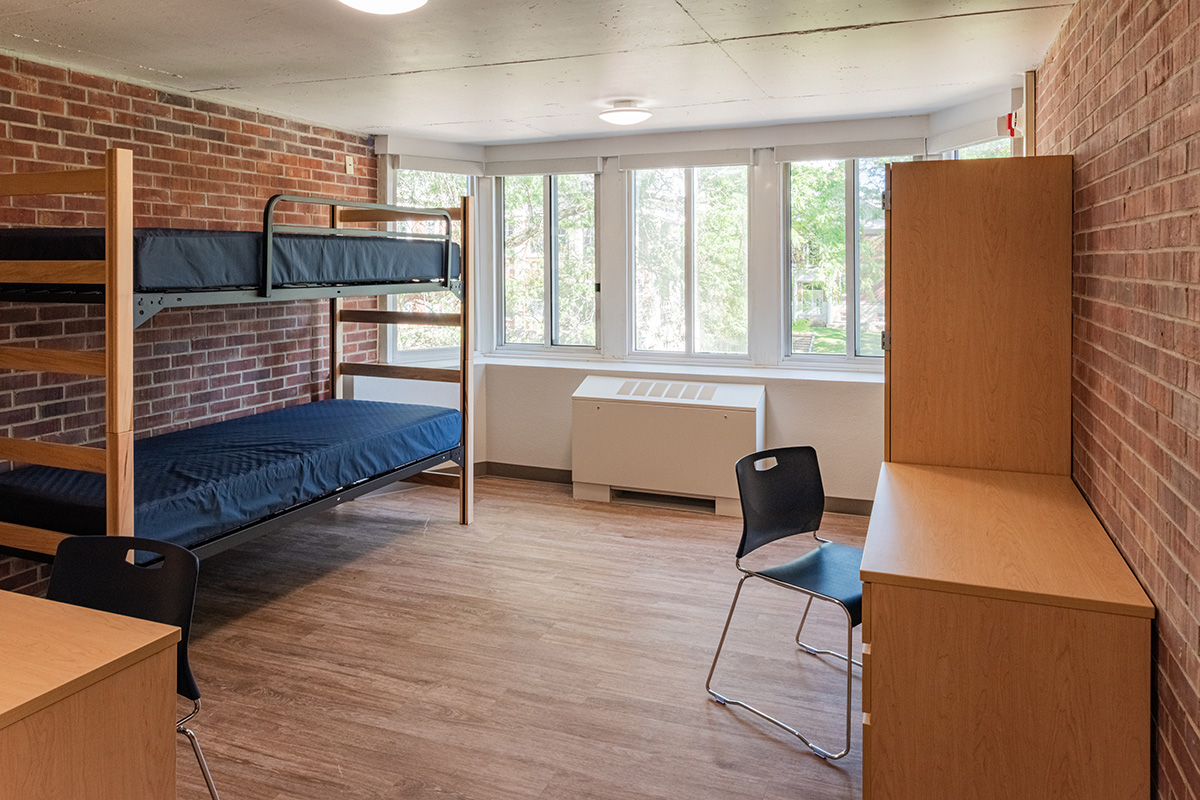 Beloit College Whitney Hall Dormitory Room Dormitory room at Beloit College Whitney Hall with bunk beds, wood desk, exposed brick wall, and windows overlooking campus
