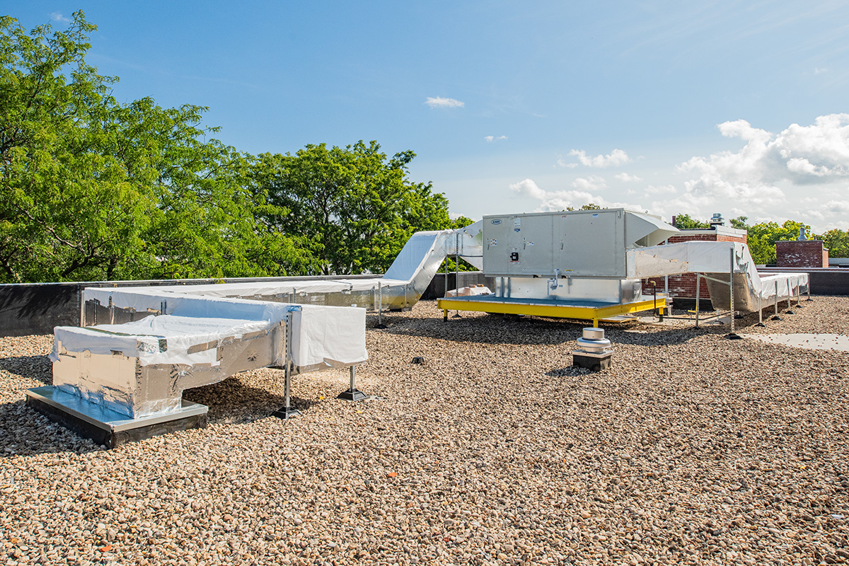 Rooftop view at Beloit College Whitney Hall showing mechanical equipment with tree canopy in the background